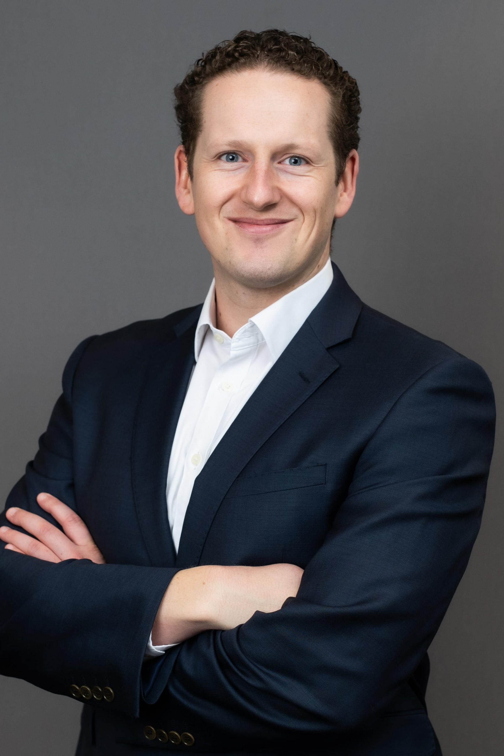 Jacob Ross, a man in a suit posing for a photo.