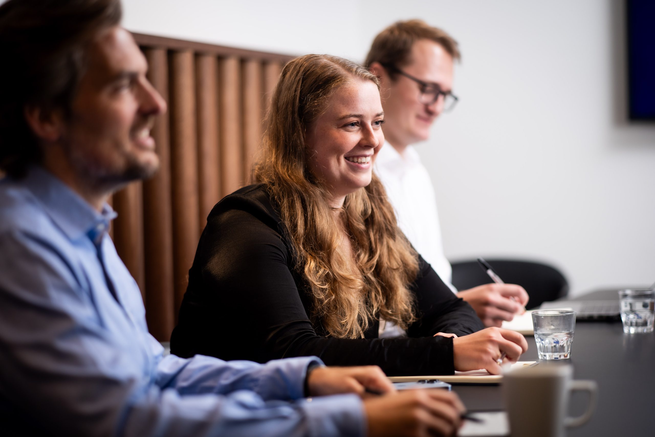 A group of people sitting at a table in a conference room discussing Kilter Finance.